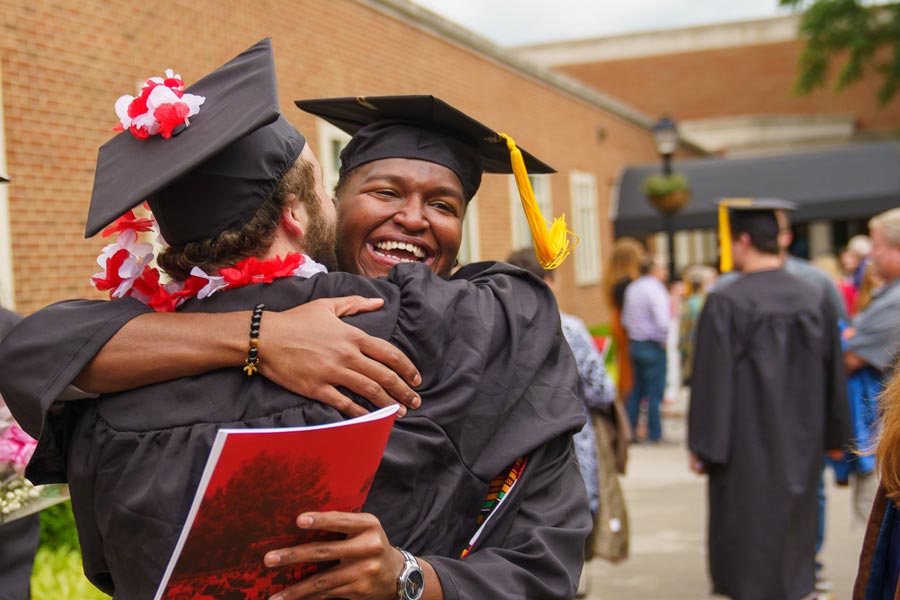 students hugging after commencement